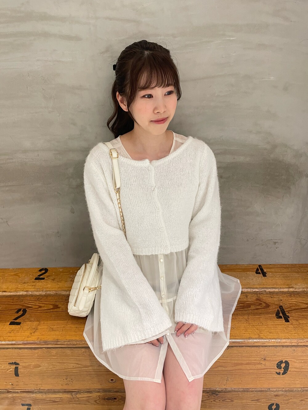 ホワイト系のニット/セーター、ホワイト系のチュニック、ホワイト系のスカートを着用したレディースの秋コーディネートの5枚目の写真