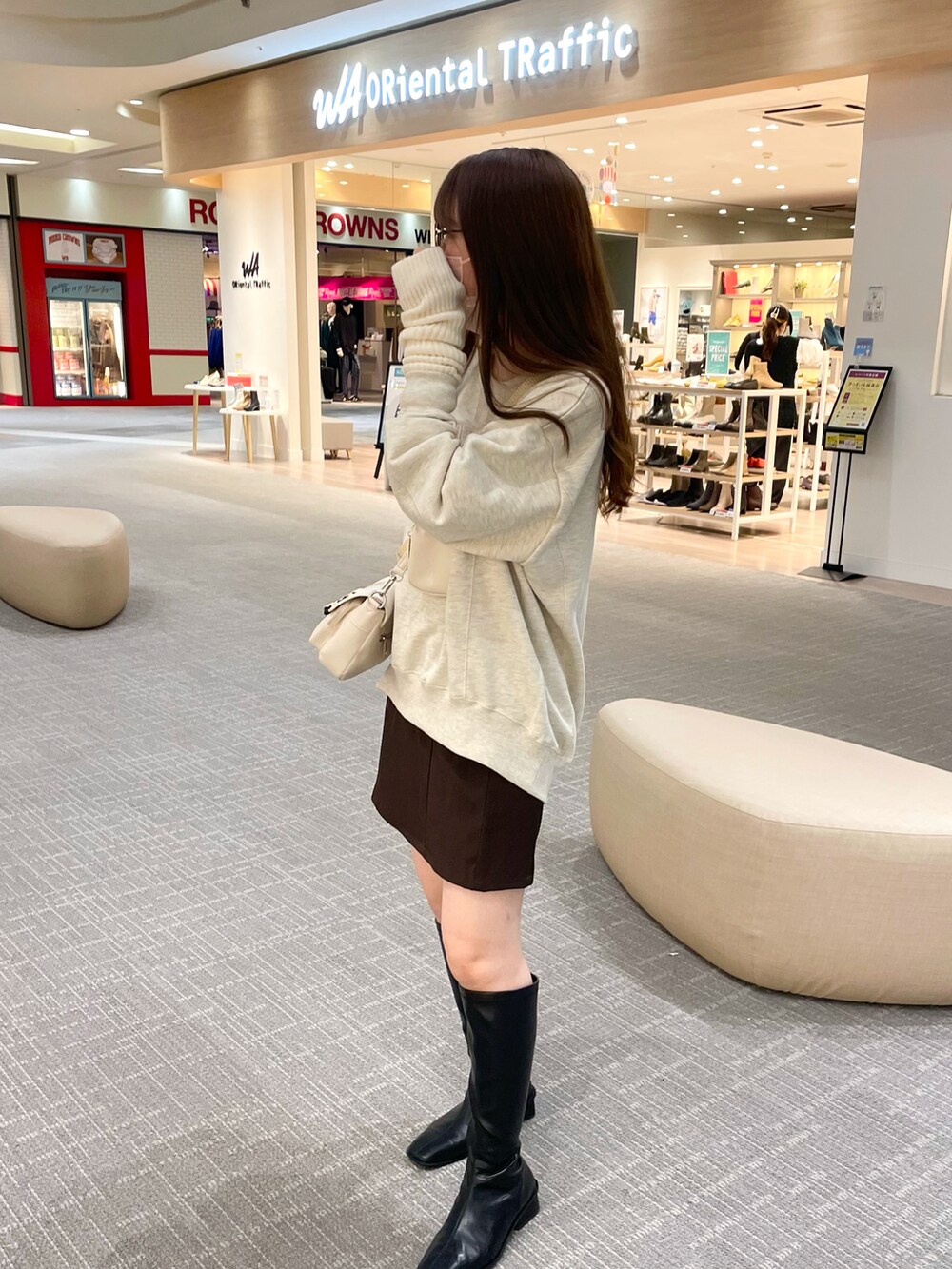 ベージュ系のスウェット、ホワイト系のショルダーバッグ、ブラウン系のスカートを着用したレディースの秋コーディネートの5枚目の写真