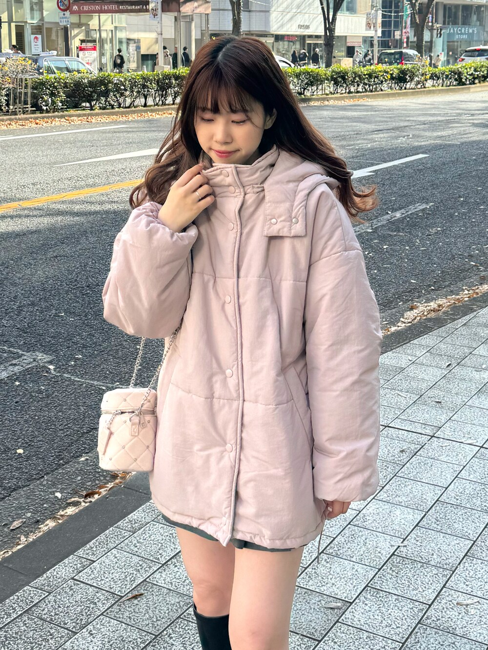 ピンク系のダウンジャケット/コート、ピンク系のショルダーバッグ、グレー系のスカートを着用したレディースの冬コーディネートの5枚目の写真