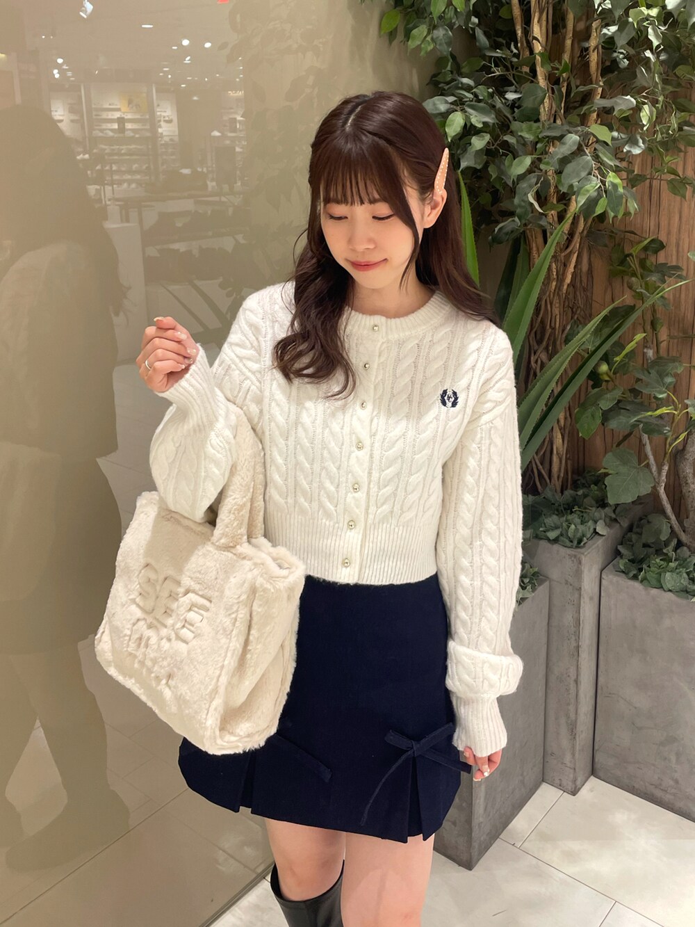 ホワイト系のカーディガン/ボレロ、ブルー系のスカート、ホワイト系のトートバッグを着用したレディースの秋コーディネートの2枚目の写真
