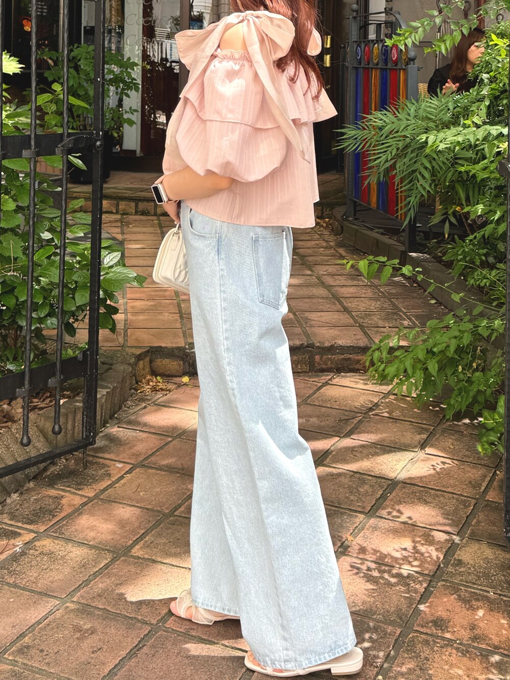 ピンク系のシャツ/ブラウス、ブルー系のデニムパンツ、ホワイト系のサンダルを着用したレディースの春コーディネートの4枚目の写真