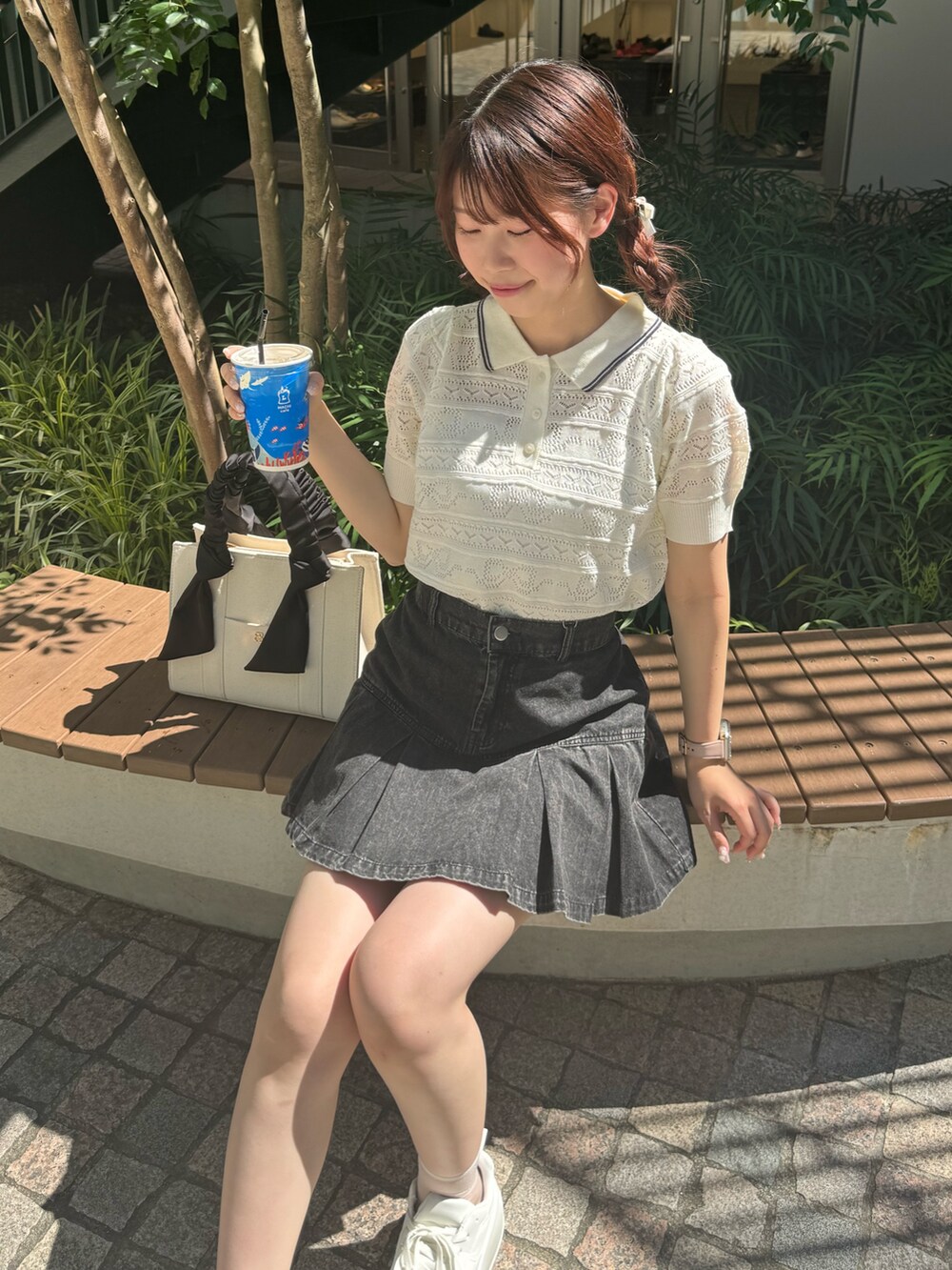 ホワイト系のニット/セーター、ブラック系のスカート、ホワイト系のスニーカーを着用したレディースの夏コーディネートの5枚目の写真