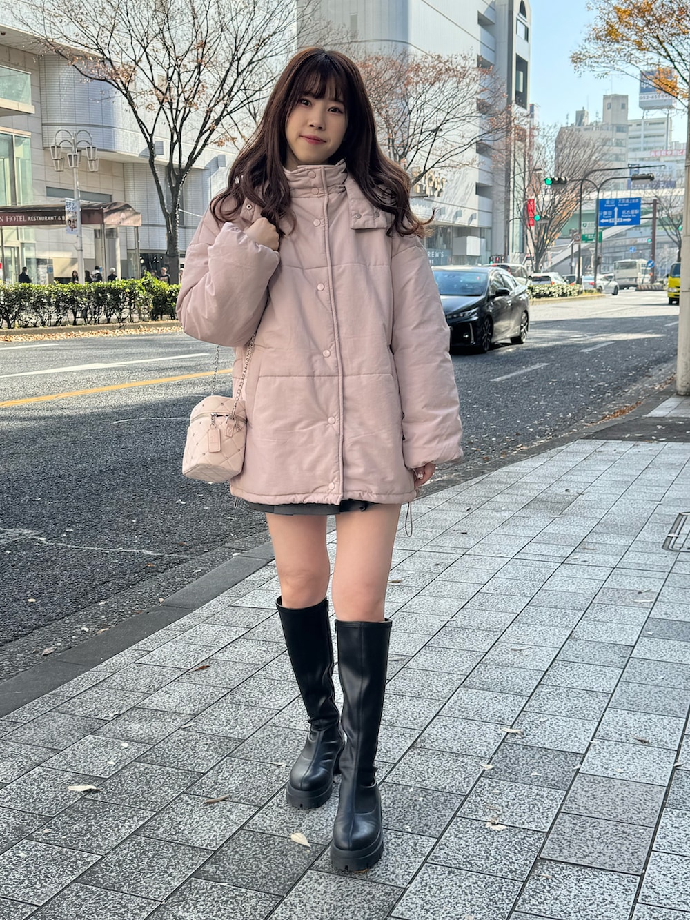 ピンク系のダウンジャケット/コート、ピンク系のショルダーバッグを着用したレディースの冬コーディネートの2枚目の写真