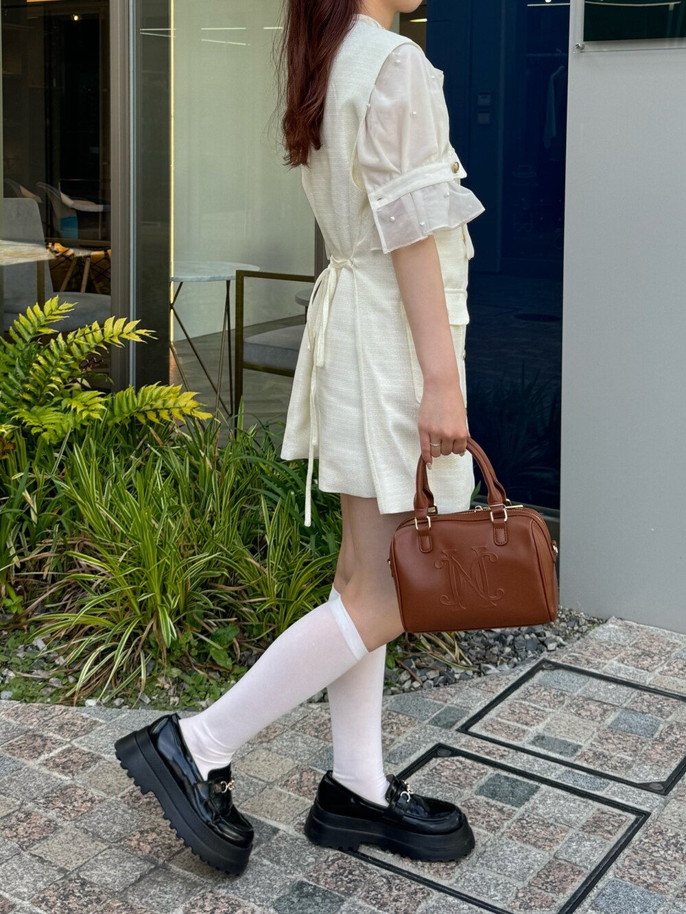 ホワイト系のシャツ/ブラウス、ホワイト系のベスト、ブラウン系のボストンバッグを着用したレディースの夏コーディネートの4枚目の写真