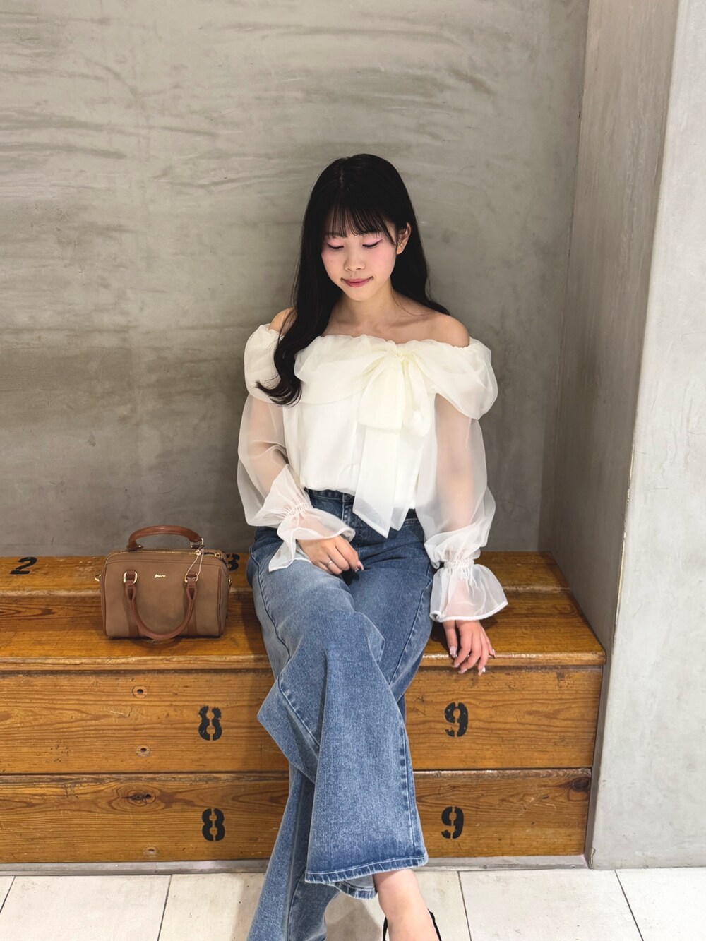 ホワイト系のシャツ/ブラウス、ブルー系のデニムパンツ、イエロー系のボストンバッグを着用したレディースの春コーディネートの3枚目の写真