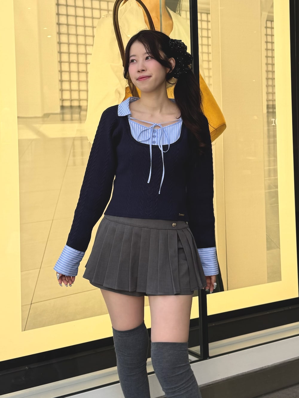 ブルー系のニット/セーター、グレー系のスカート、ブラック系のローファーを着用したレディースの冬コーディネートの5枚目の写真