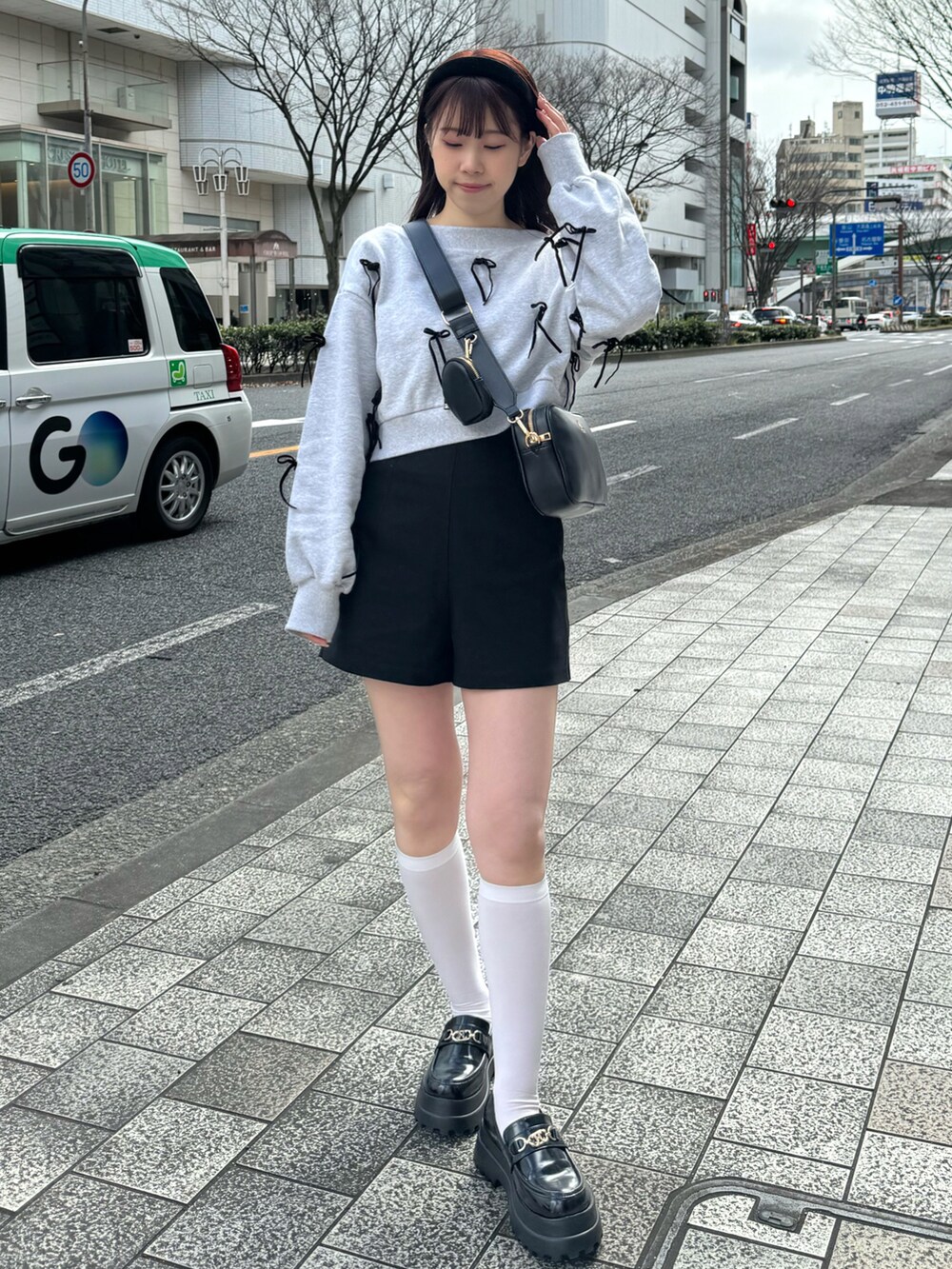 グレー系のスウェット、ブラック系のボディバッグ/ウエストポーチ、ブラック系のパンツを着用したレディースの春コーディネートの2枚目の写真