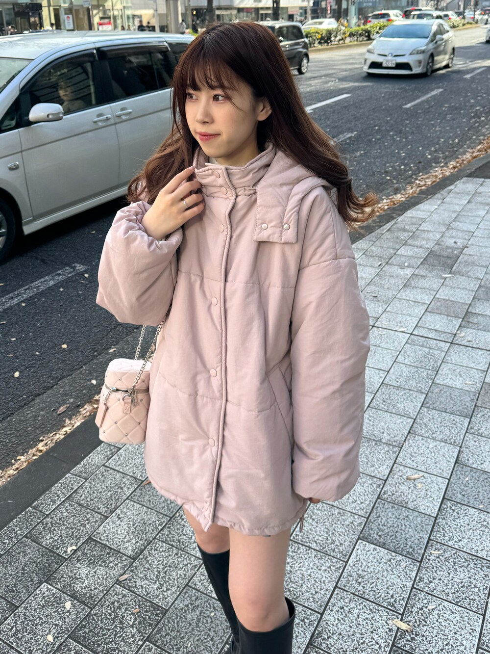 ピンク系のダウンジャケット/コート、ピンク系のショルダーバッグ、グレー系のスカートを着用したレディースの冬コーディネートの2枚目の写真