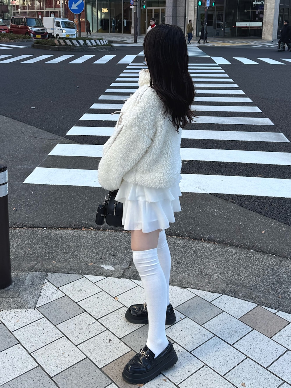 ホワイト系のブルゾン、ホワイト系のスカート、ブラック系のハンドバッグを着用したレディースの冬コーディネートの3枚目の写真