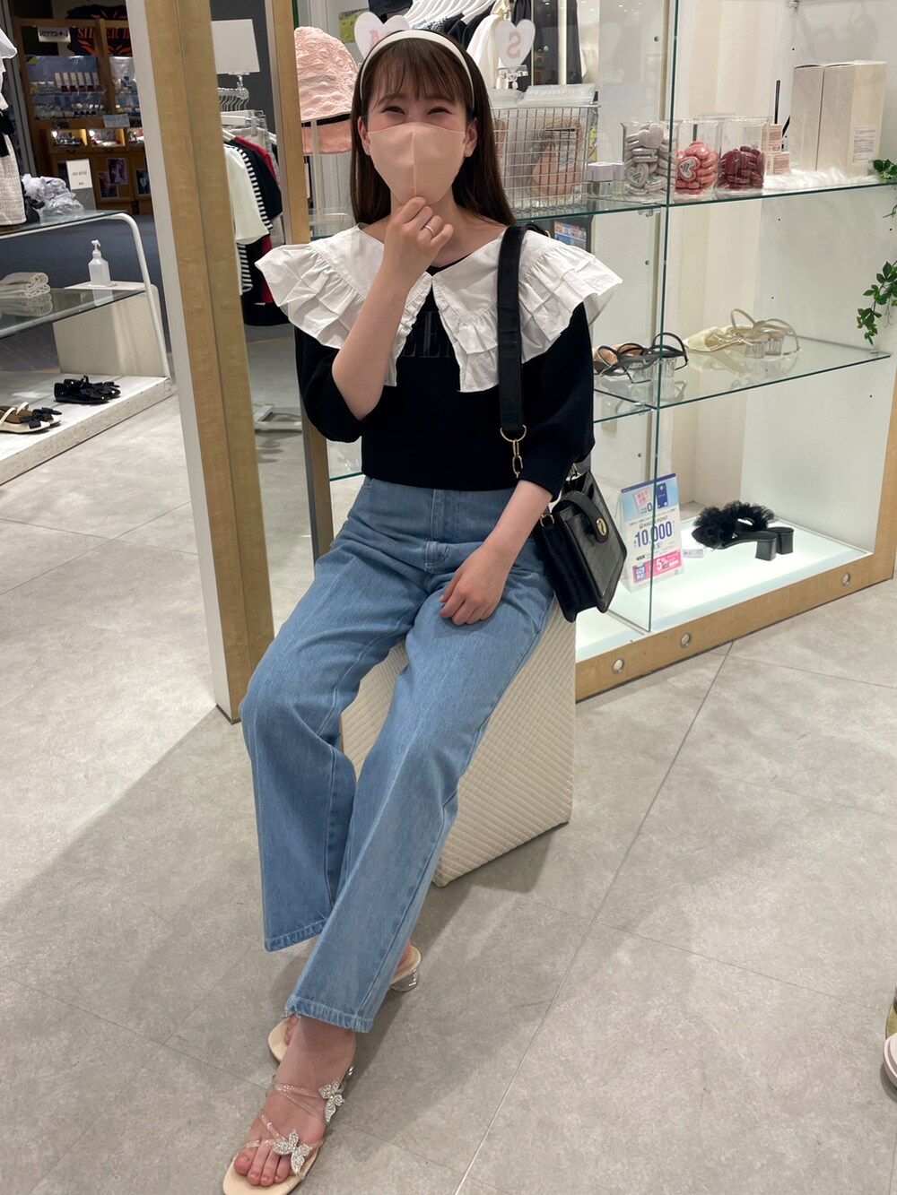 ブラック系のスウェット、ブルー系のデニムパンツ、その他のサンダルを着用したレディースの春コーディネートの2枚目の写真