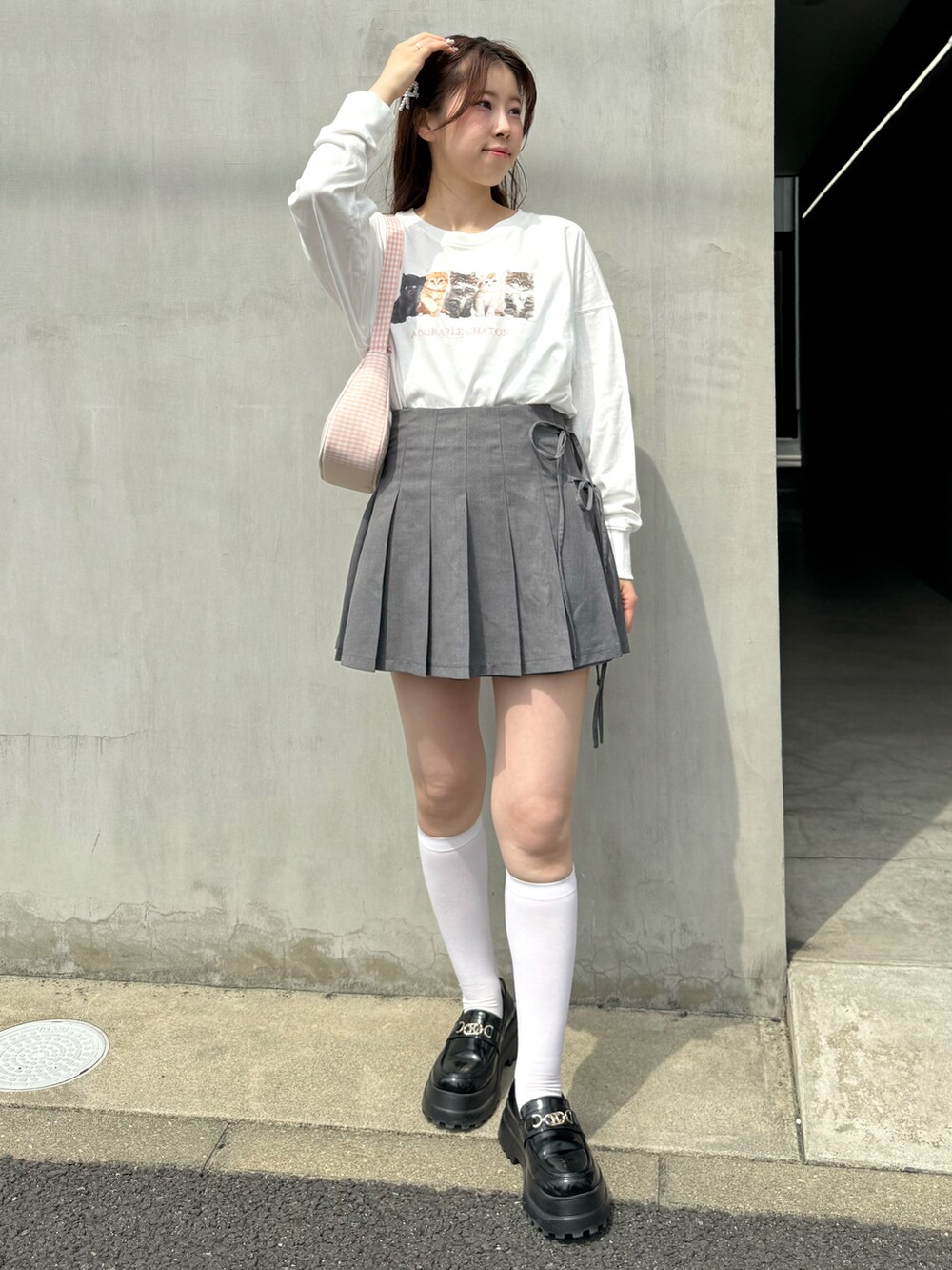 ホワイト系のTシャツ/カットソー、グレー系のスカート、ピンク系のショルダーバッグを着用したレディースの春コーディネートの4枚目の写真