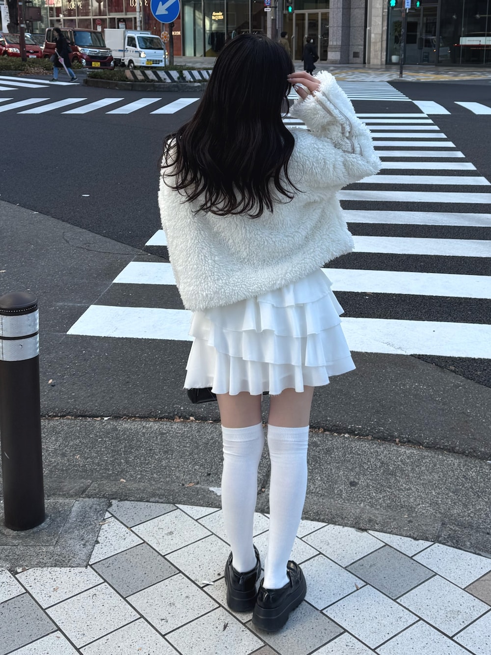 ホワイト系のブルゾン、ホワイト系のスカート、ブラック系のハンドバッグを着用したレディースの冬コーディネートの4枚目の写真