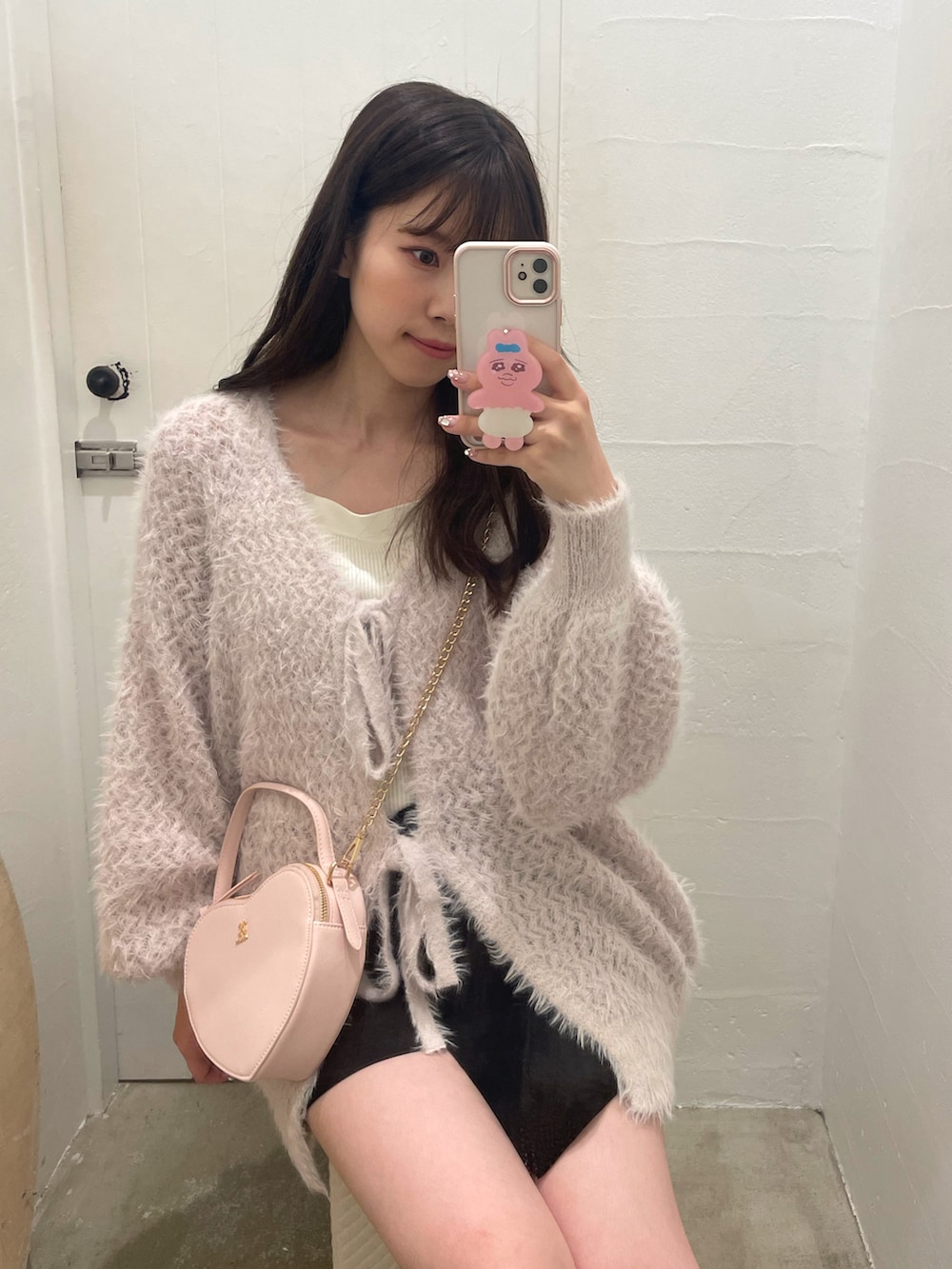 ピンク系のカーディガン/ボレロ、ホワイト系のショルダーバッグ、ブラック系のその他パンツを着用したレディースの秋コーディネートの4枚目の写真