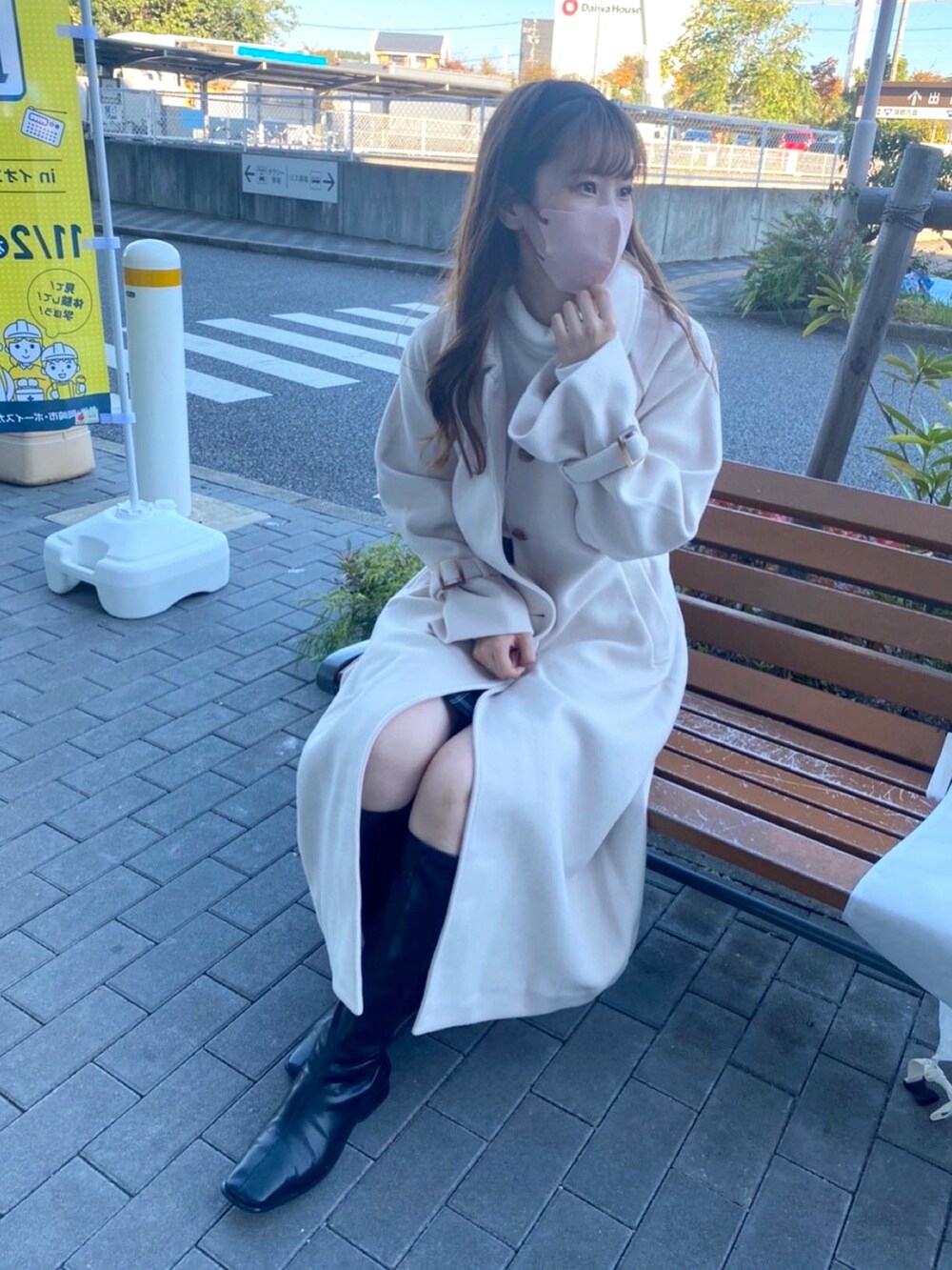 ホワイト系のステンカラーコートを着用したレディースの秋コーディネートの3枚目の写真