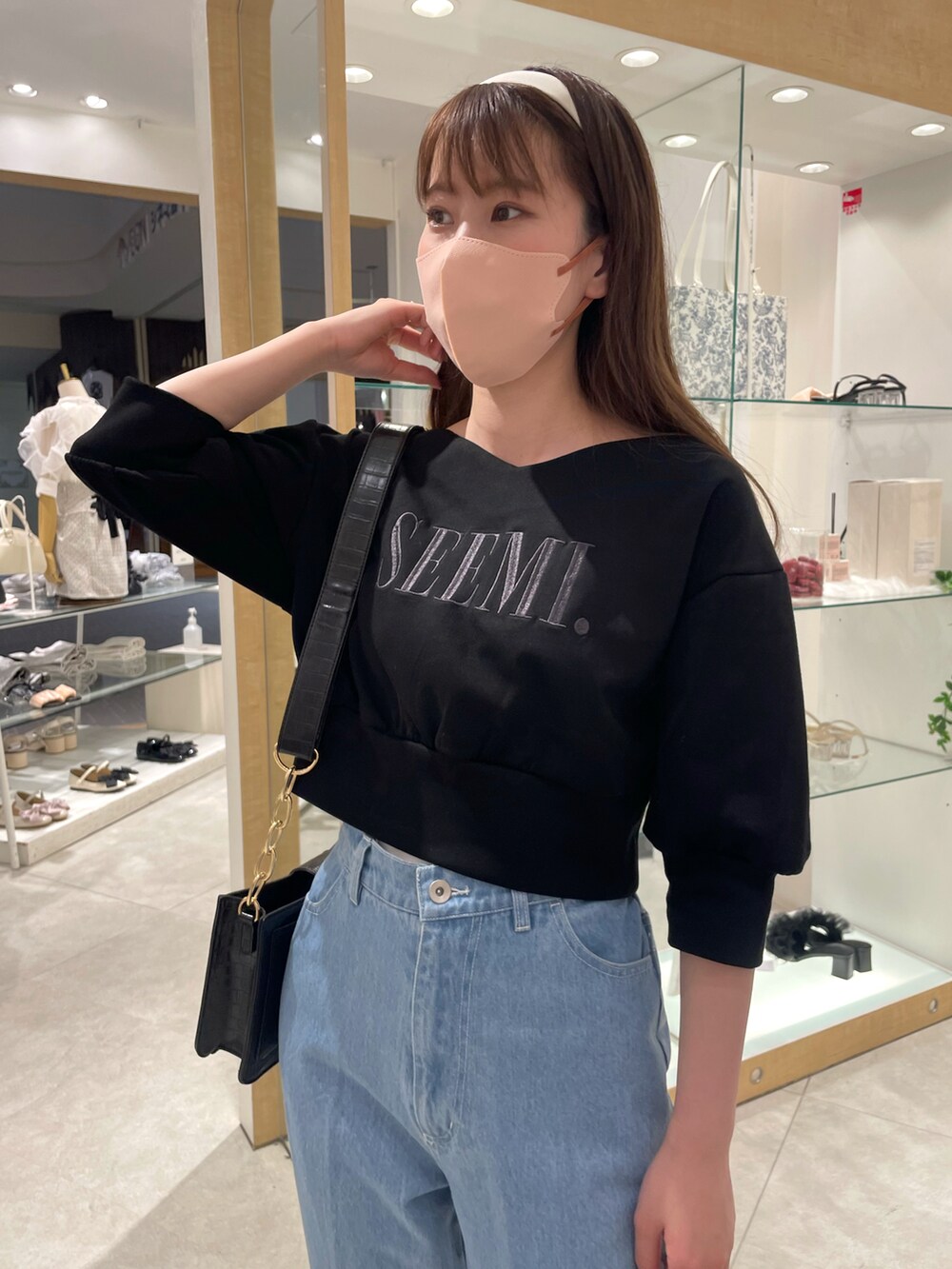 ブラック系のスウェット、ブルー系のデニムパンツ、その他のサンダルを着用したレディースの春コーディネートの5枚目の写真