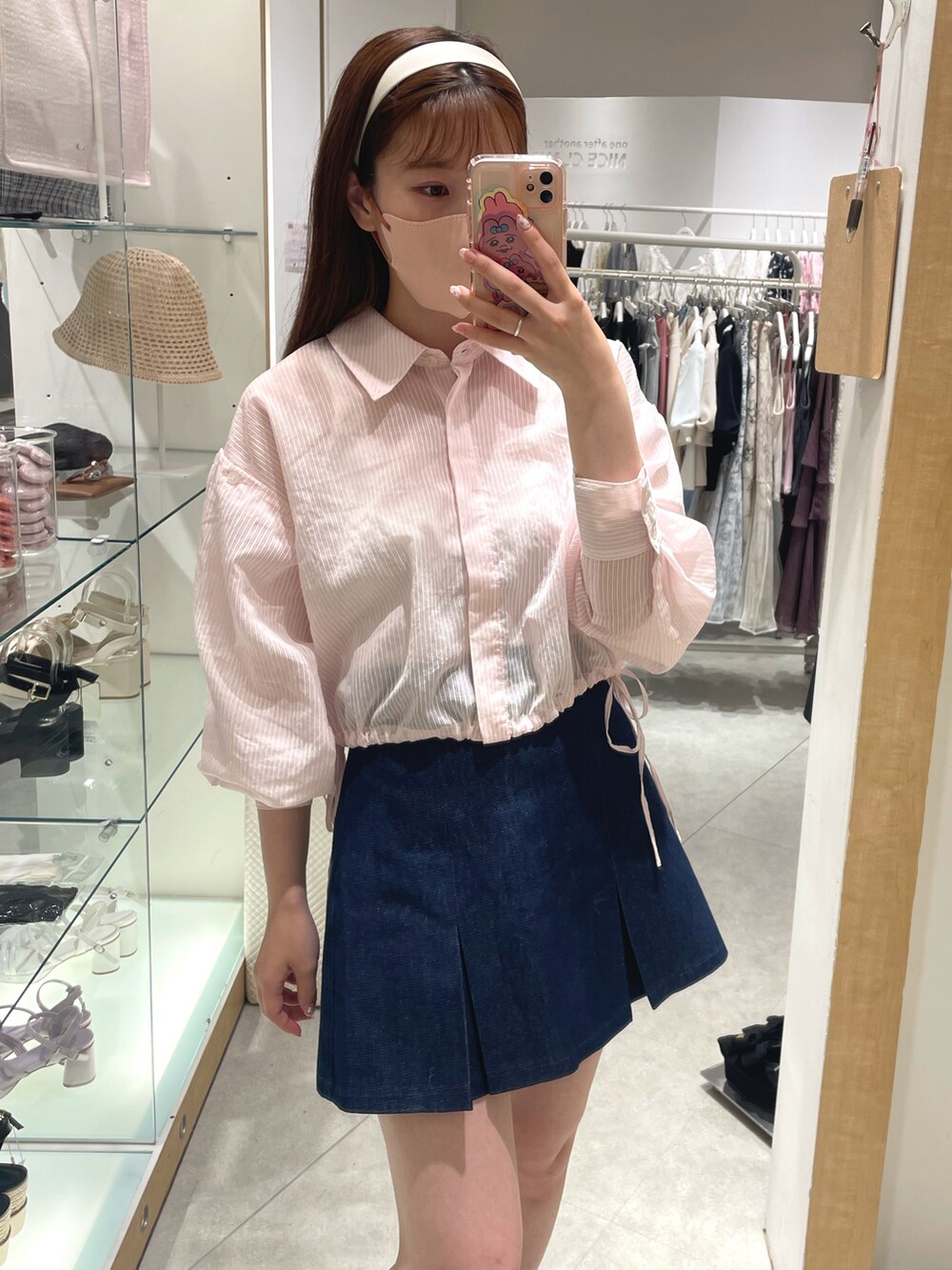 ピンク系のシャツ/ブラウス、ブルー系のスカート、ホワイト系のサンダルを着用したレディースの春コーディネートの2枚目の写真