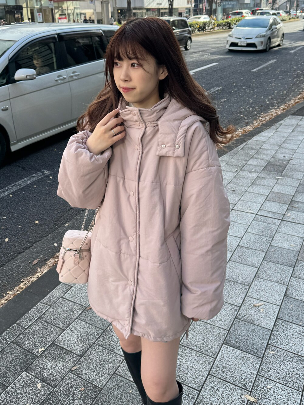 ピンク系のダウンジャケット/コート、ピンク系のショルダーバッグを着用したレディースの冬コーディネートの5枚目の写真