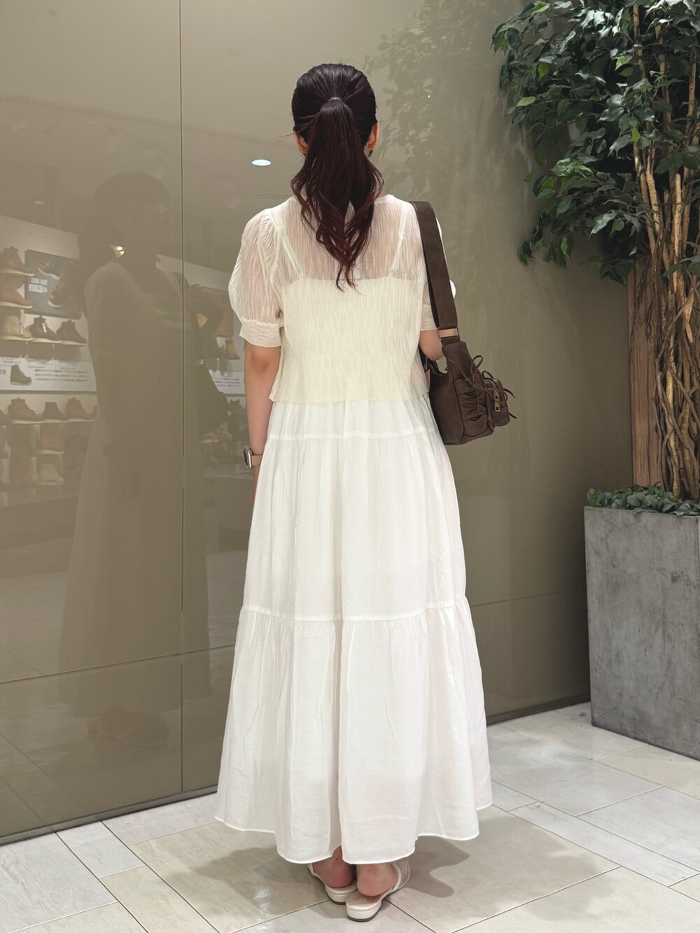 ホワイト系のカーディガン/ボレロ、ホワイト系のワンピース/ドレス、ブラウン系のショルダーバッグを着用したレディースの夏コーディネートの3枚目の写真