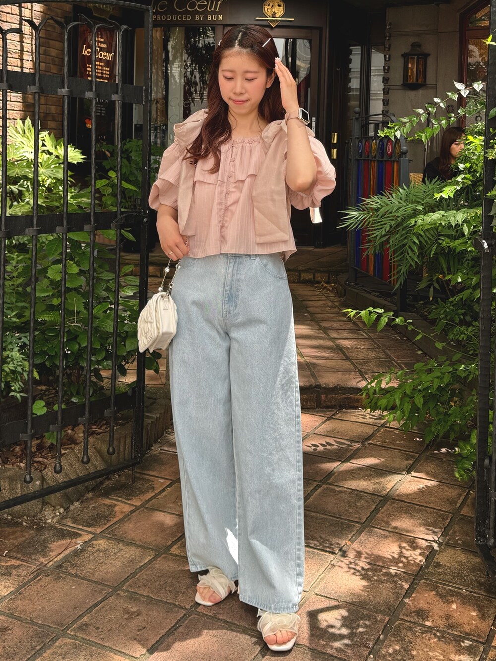 ピンク系のシャツ/ブラウス、ブルー系のデニムパンツ、ホワイト系のサンダルを着用したレディースの春コーディネートの3枚目の写真