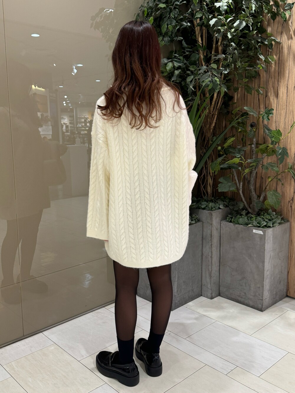 ホワイト系のワンピース、ホワイト系のトートバッグを着用したレディースの冬コーディネートの3枚目の写真