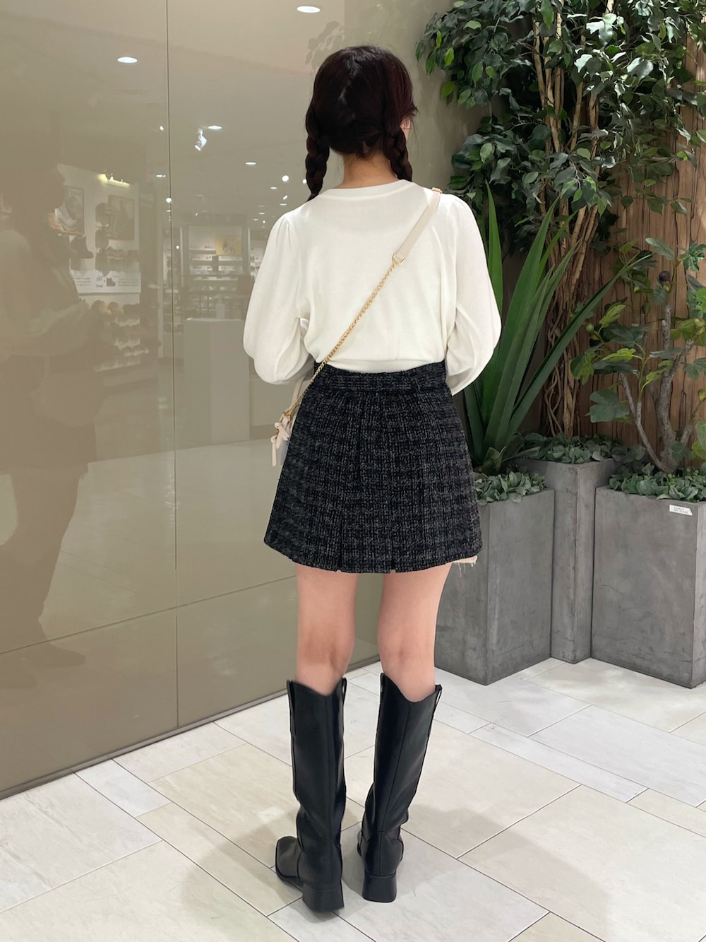 ホワイト系のカーディガン/ボレロ、ブラック系のスカート、ホワイト系のショルダーバッグを着用したレディースの秋コーディネートの4枚目の写真