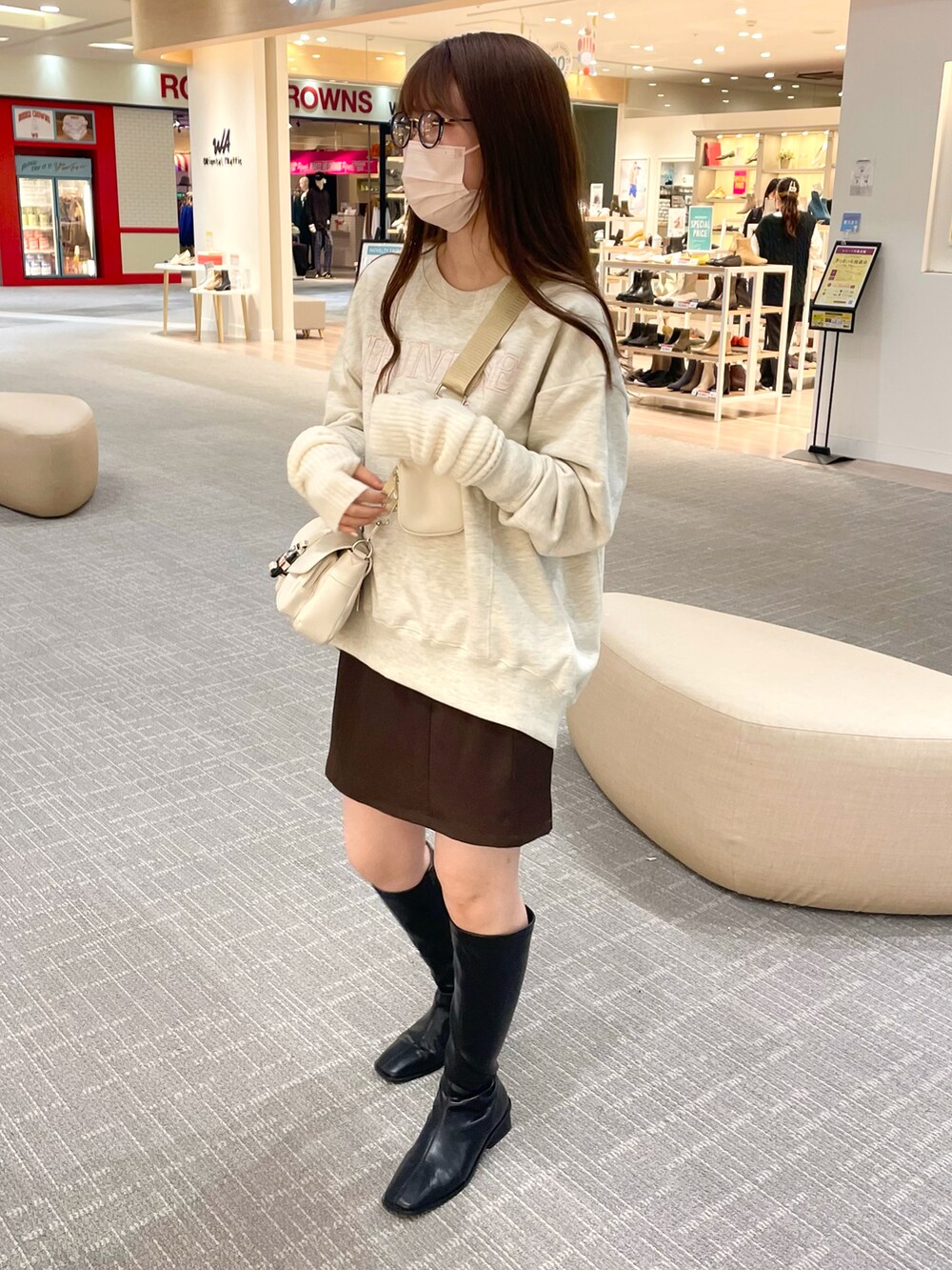 ベージュ系のスウェット、ホワイト系のショルダーバッグ、ブラウン系のスカートを着用したレディースの秋コーディネートの3枚目の写真