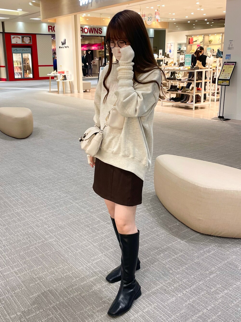 ベージュ系のスウェット、ホワイト系のショルダーバッグ、ブラウン系のスカートを着用したレディースの秋コーディネートの4枚目の写真