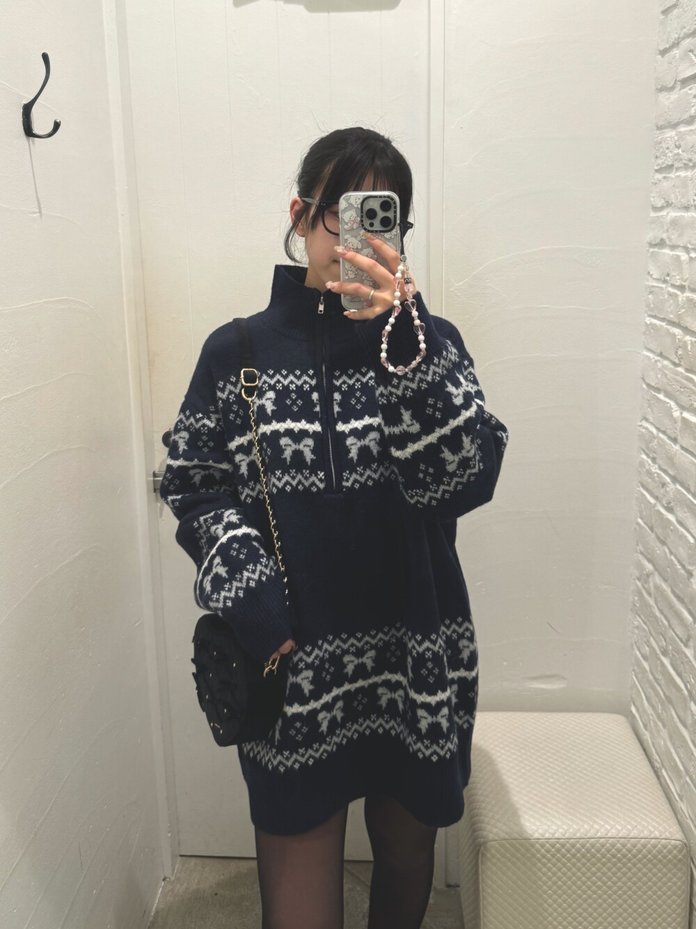 ブルー系のチュニック、ブラック系のショルダーバッグを着用したレディースの冬コーディネートの4枚目の写真