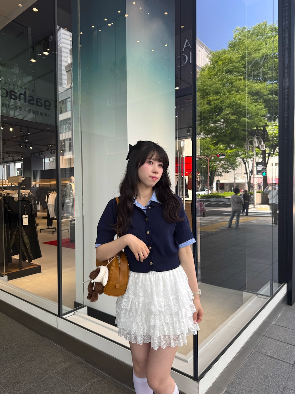 ブルー系のニット/セーター、ホワイト系のスカート、ホワイト系のスニーカーを着用したレディースの春コーディネートの6枚目の写真