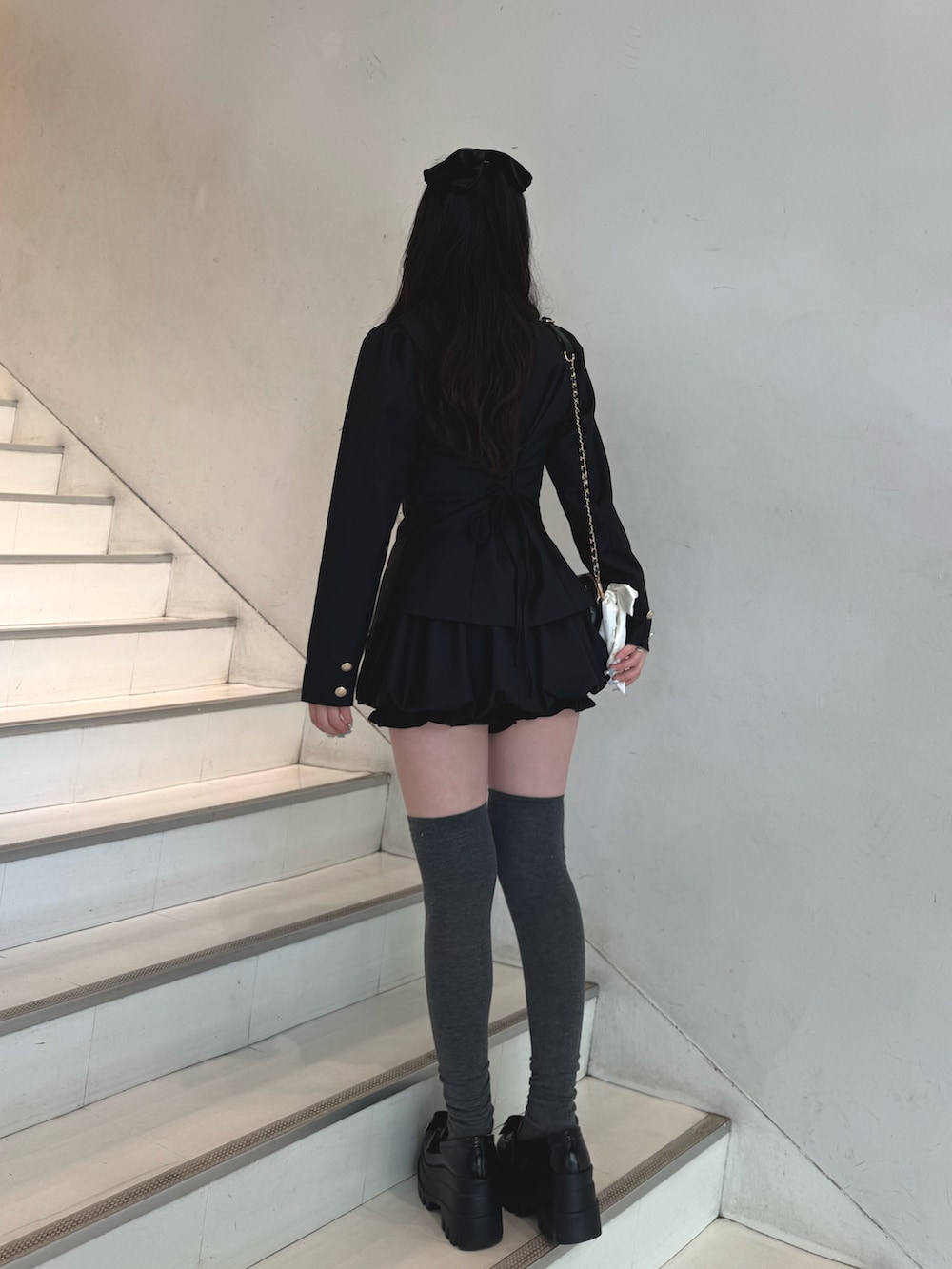 ブラック系のテーラードジャケット、ブラック系のスカート、その他のシャツ/ブラウスを着用したレディースの冬コーディネートの4枚目の写真