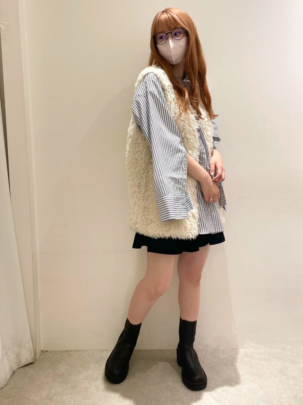 ブルー系のシャツ/ブラウス、ブラック系のスカート、ブラック系のブーツを着用したレディースの秋コーディネートの2枚目の写真