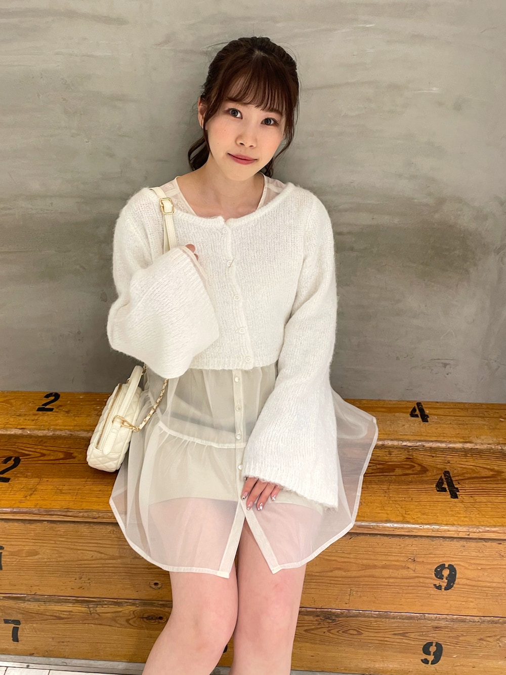 ホワイト系のニット/セーター、ホワイト系のチュニック、ホワイト系のスカートを着用したレディースの秋コーディネートの5枚目の写真