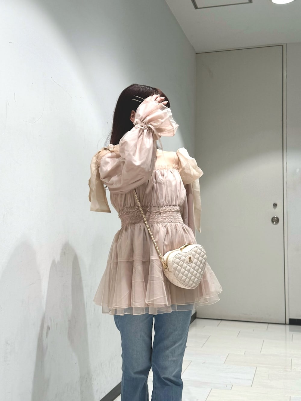 ブルー系のデニムパンツ、ベージュ系のショルダーバッグ、ピンク系のシャツ/ブラウスを着用したレディースの春コーディネートの4枚目の写真