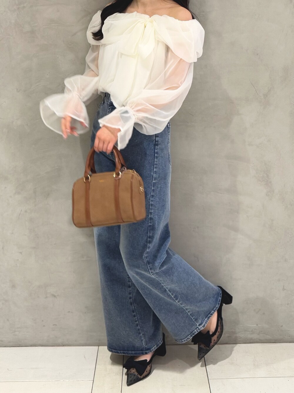 ホワイト系のシャツ/ブラウス、ブルー系のデニムパンツ、イエロー系のボストンバッグを着用したレディースの春コーディネートの4枚目の写真