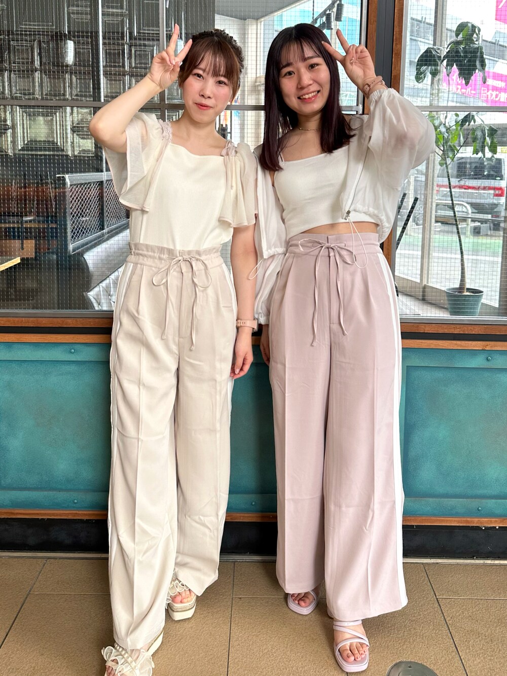 ホワイト系のTシャツ/カットソー、ベージュ系のスラックスを着用したレディースの春コーディネートの2枚目の写真