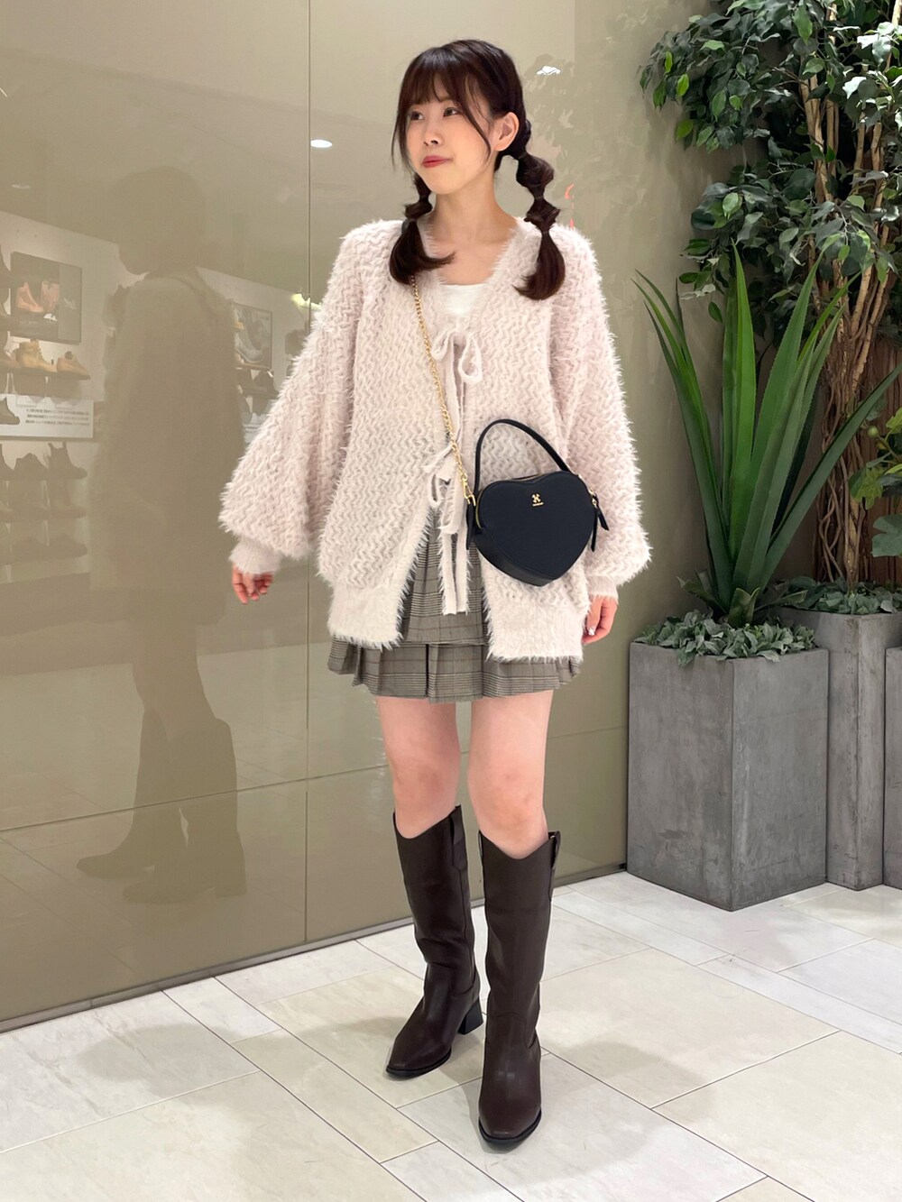 ピンク系のカーディガン/ボレロ、その他のスカート、ホワイト系のショルダーバッグを着用したレディースの秋コーディネートの3枚目の写真