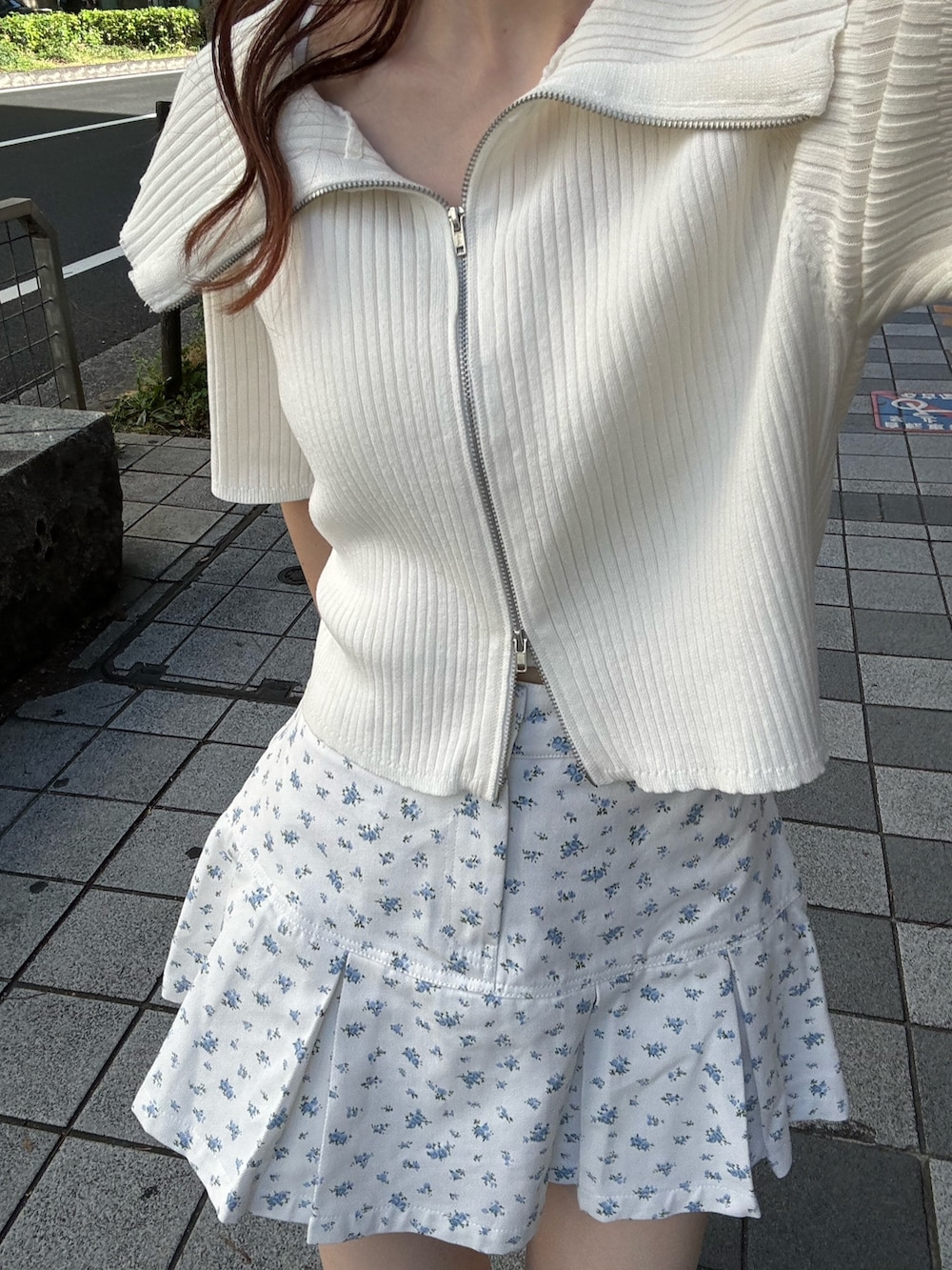 ホワイト系のニット/セーター、ブルー系のスカート、ホワイト系のスニーカーを着用したレディースの春コーディネートの5枚目の写真