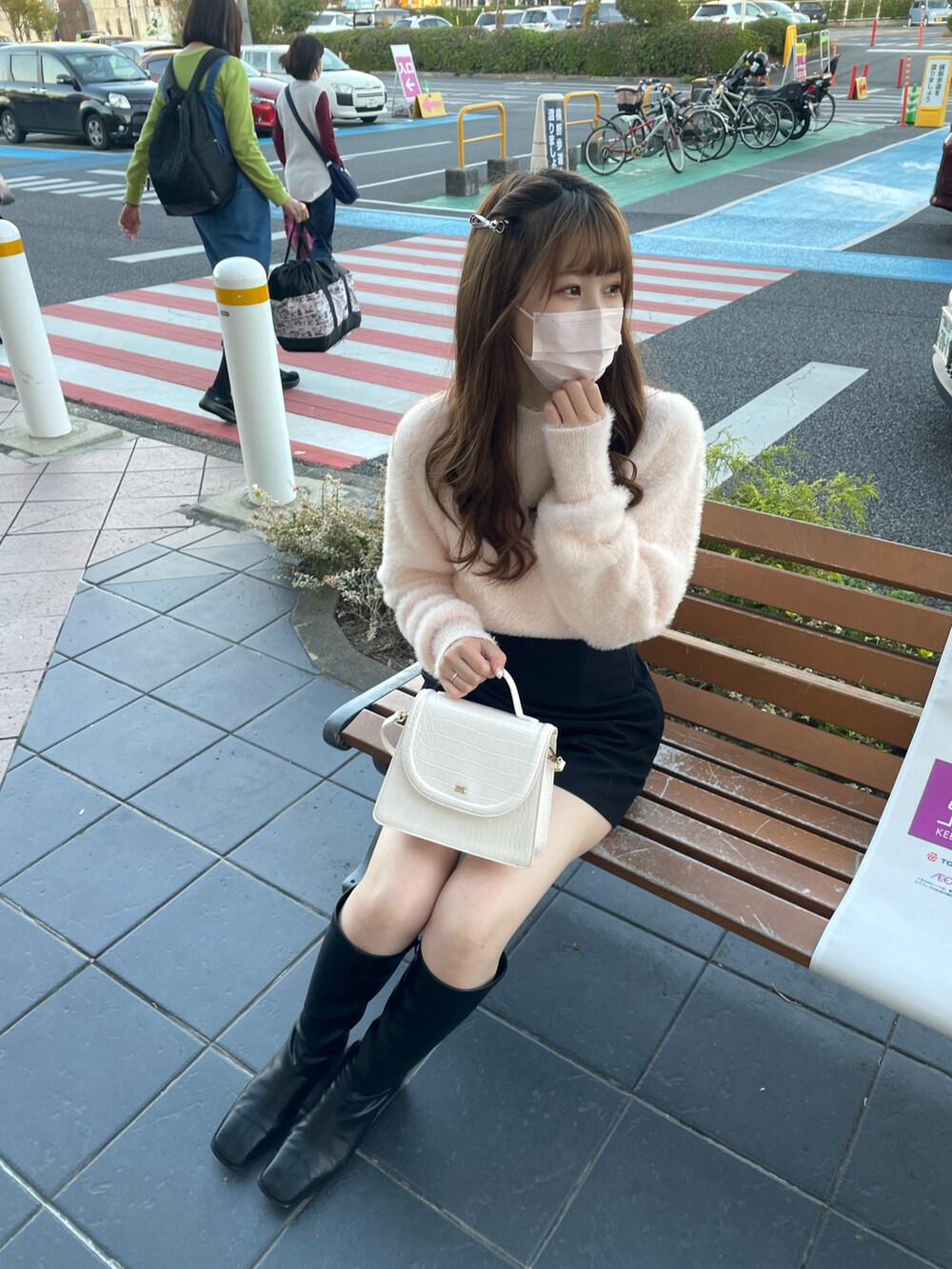 ピンク系のニット/セーター、ブラック系のその他パンツ、ホワイト系のショルダーバッグを着用したレディースの秋コーディネートの3枚目の写真