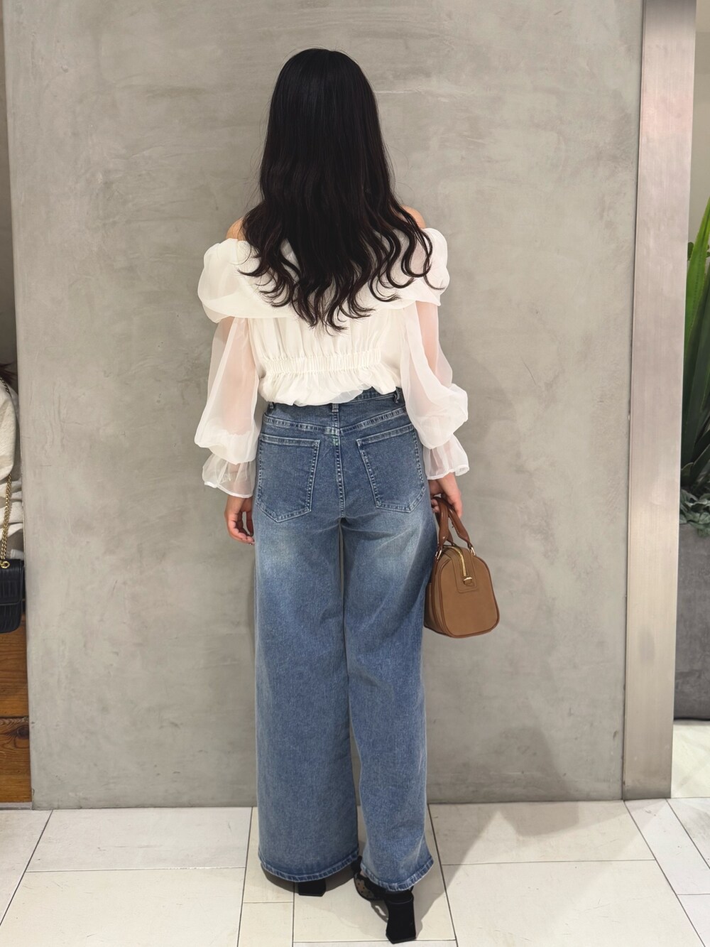 ホワイト系のシャツ/ブラウス、ブルー系のデニムパンツ、イエロー系のボストンバッグを着用したレディースの春コーディネートの5枚目の写真