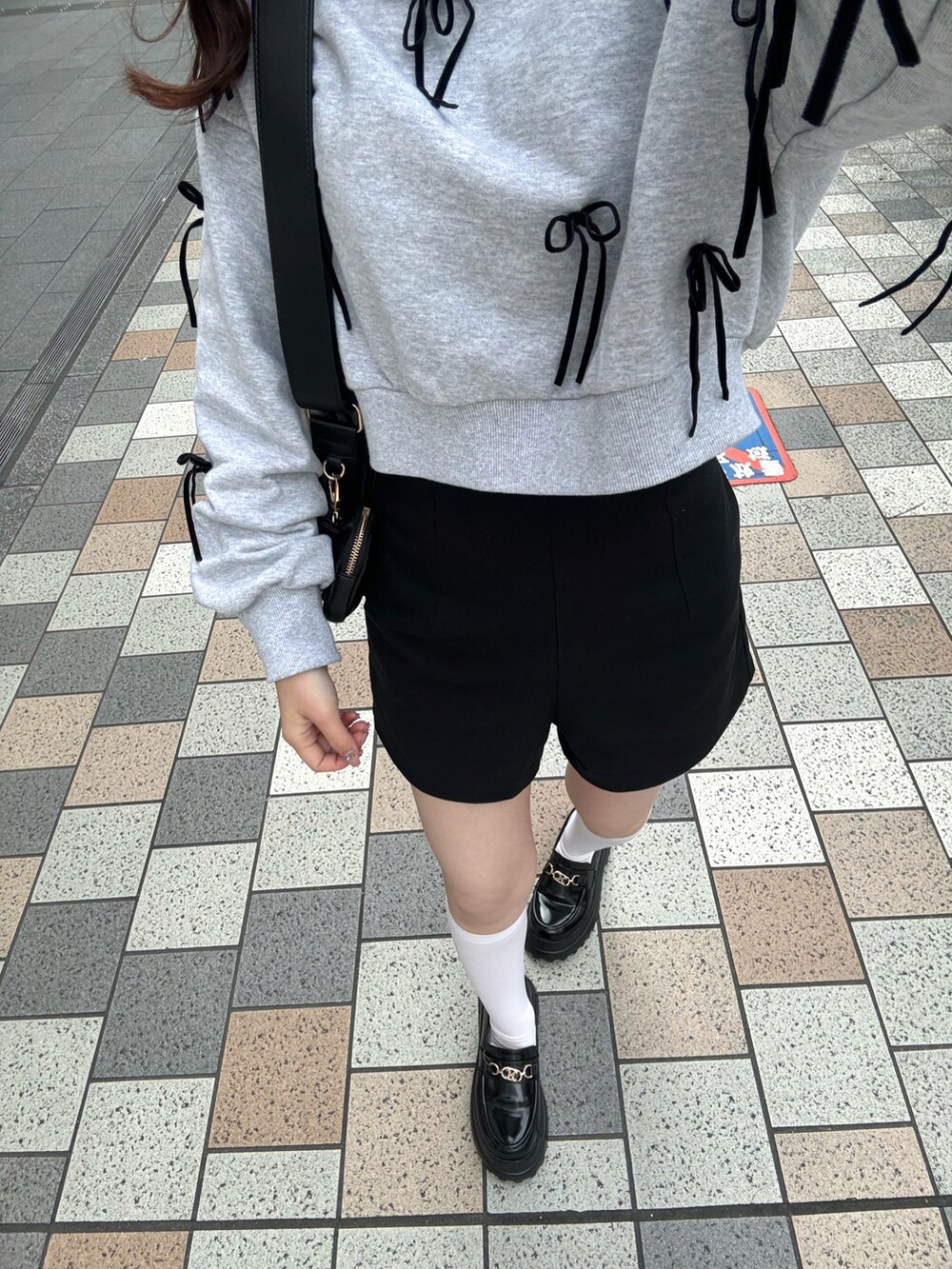 グレー系のスウェット、ブラック系のボディバッグ/ウエストポーチ、ブラック系のパンツを着用したレディースの春コーディネートの5枚目の写真