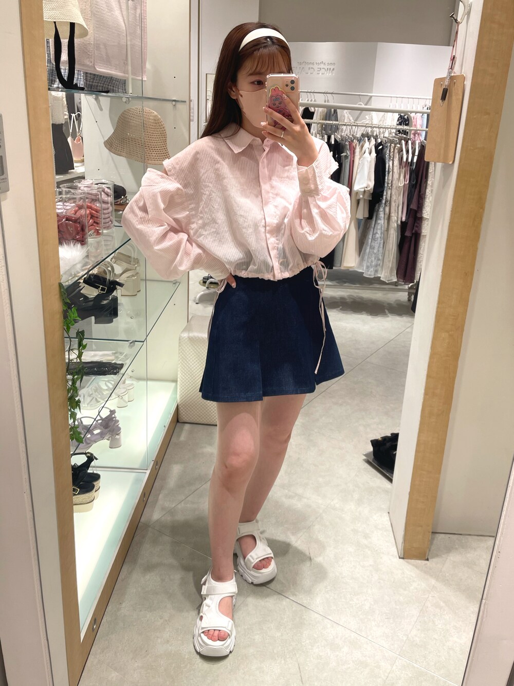 ピンク系のシャツ/ブラウス、ブルー系のスカート、ホワイト系のサンダルを着用したレディースの春コーディネートの3枚目の写真