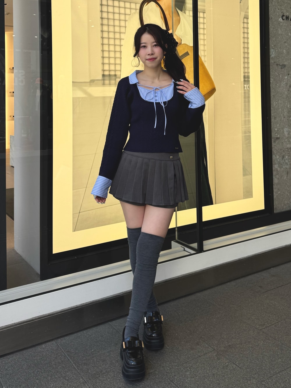 ブルー系のニット/セーター、グレー系のスカート、ブラック系のローファーを着用したレディースの冬コーディネートの4枚目の写真