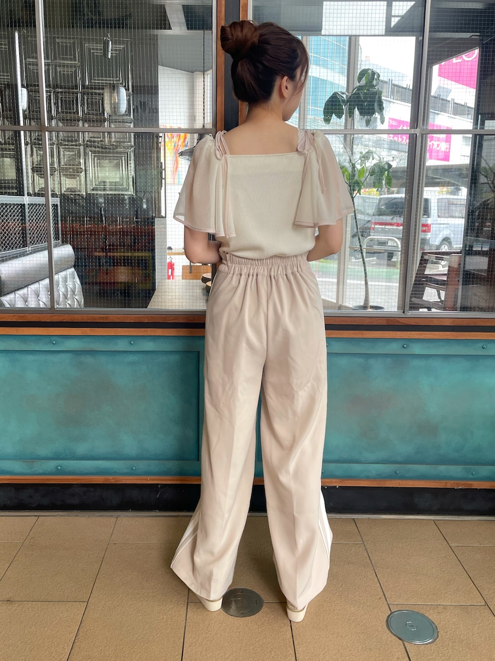 ホワイト系のTシャツ/カットソー、ベージュ系のスラックス、ブラック系のサンダルを着用したレディースの春コーディネートの3枚目の写真