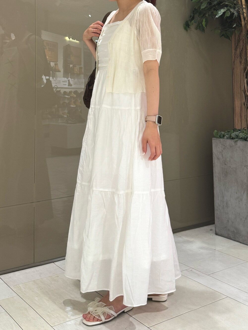 ホワイト系のカーディガン/ボレロ、ホワイト系のワンピース/ドレス、ブラウン系のショルダーバッグを着用したレディースの夏コーディネートの2枚目の写真