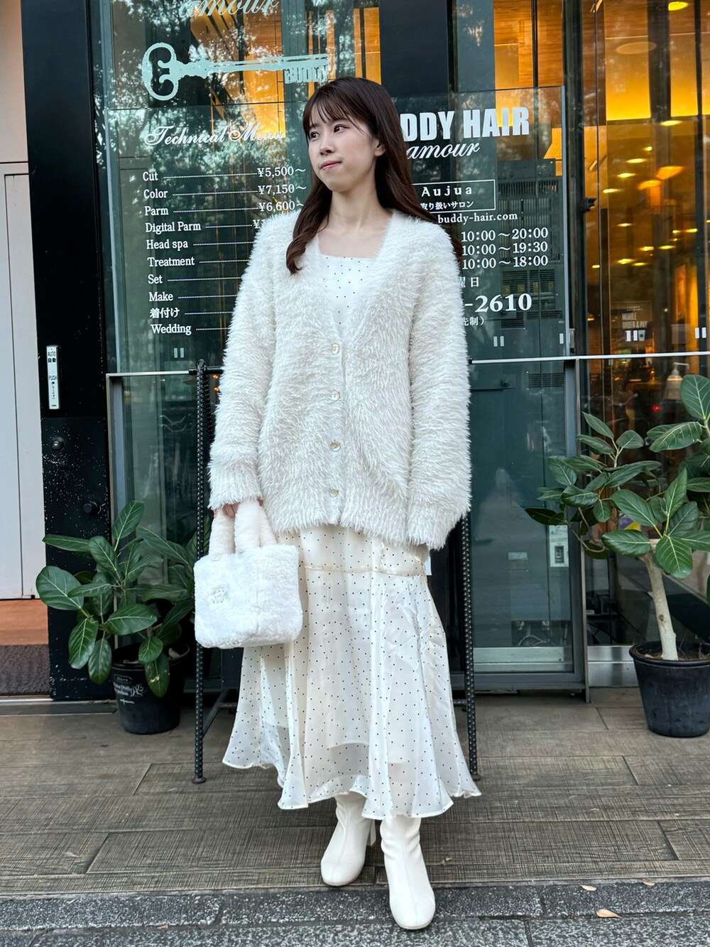 ホワイト系のカーディガン/ボレロ、ホワイト系のワンピース、ホワイト系のブーツを着用したレディースの冬コーディネートの2枚目の写真