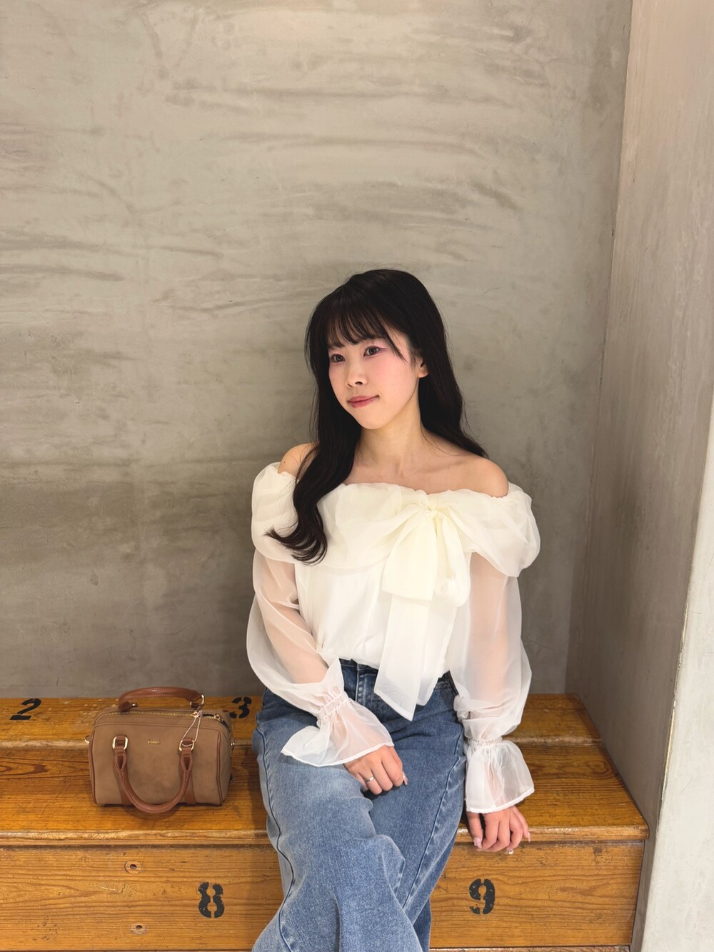 ホワイト系のシャツ/ブラウス、ブルー系のデニムパンツ、イエロー系のボストンバッグを着用したレディースの春コーディネートの7枚目の写真