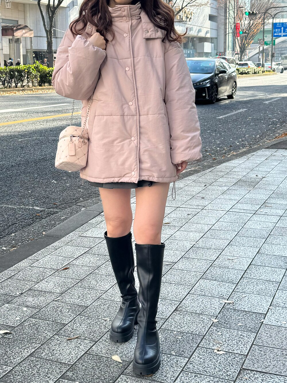 ピンク系のダウンジャケット/コート、ピンク系のショルダーバッグ、グレー系のスカートを着用したレディースの冬コーディネートの4枚目の写真