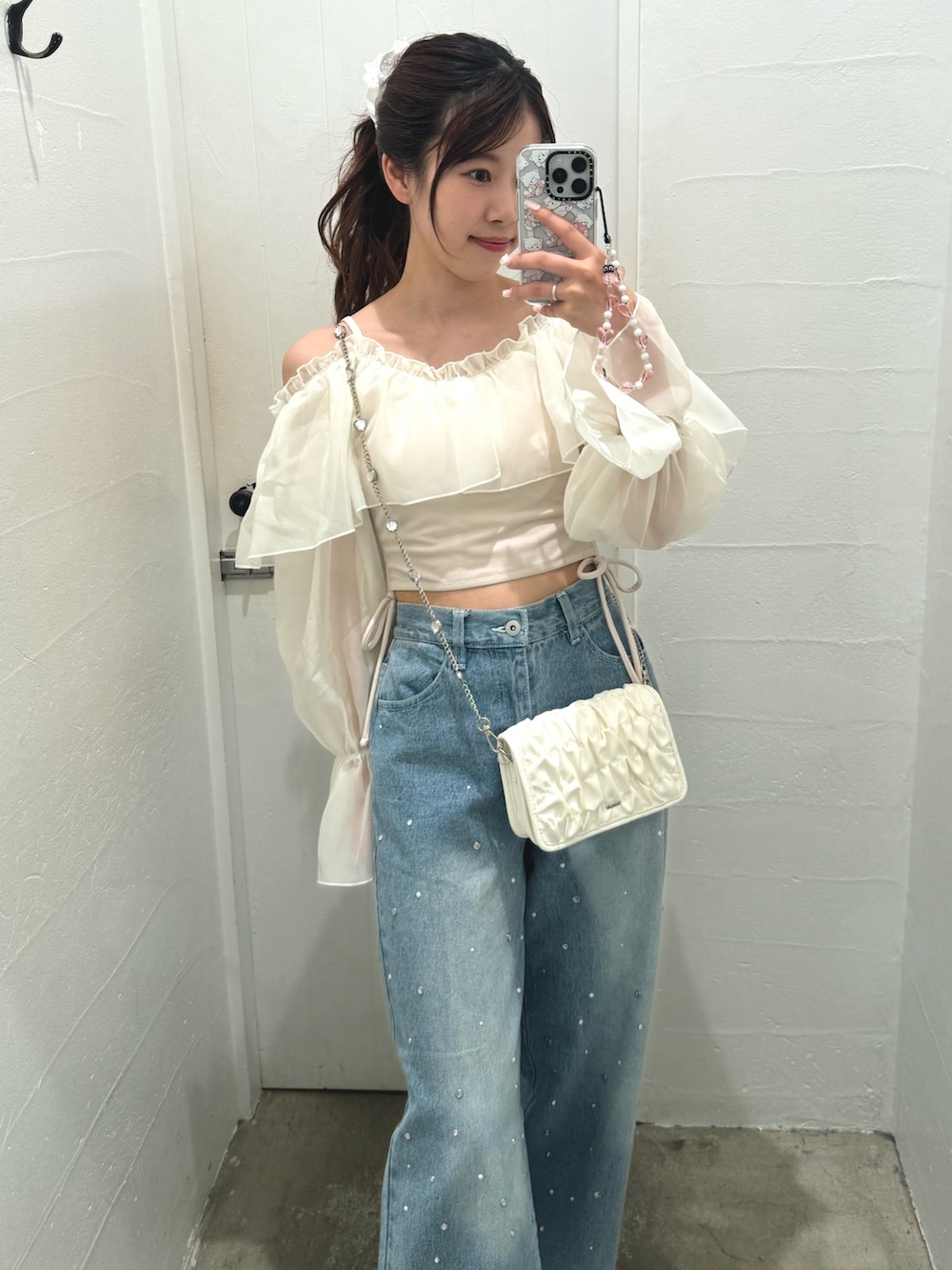 ホワイト系のショルダーバッグ、ブルー系のデニムパンツ、ホワイト系の水着を着用したレディースの夏コーディネートの3枚目の写真