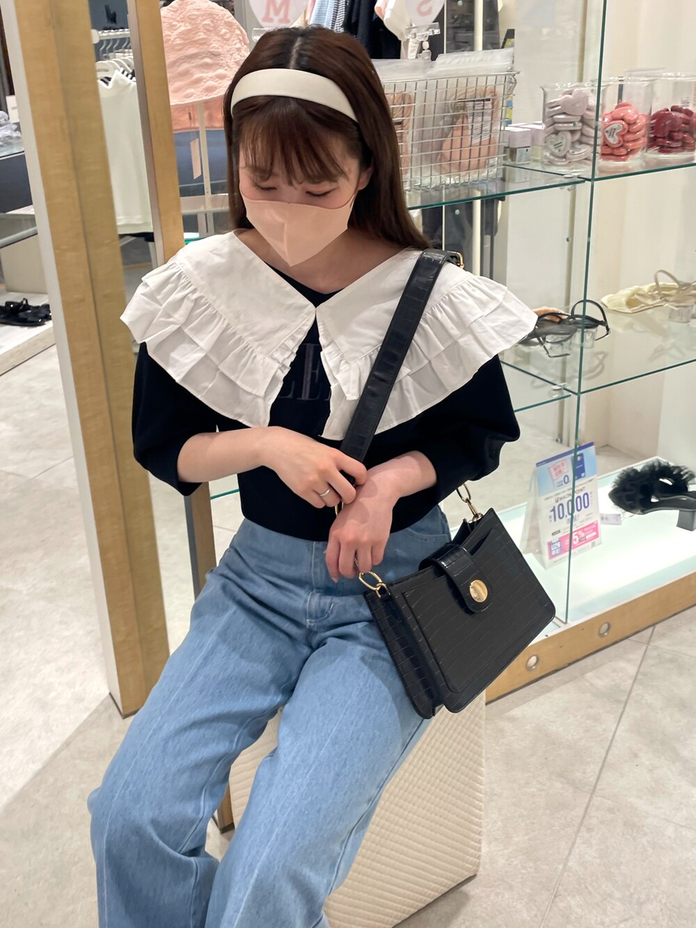 ブラック系のスウェット、ブルー系のデニムパンツ、その他のサンダルを着用したレディースの春コーディネートの3枚目の写真