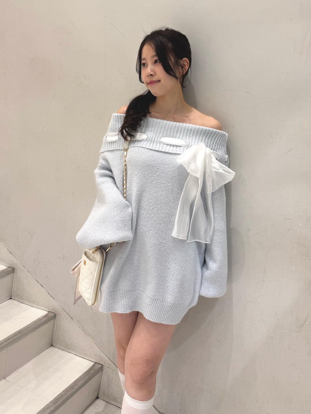 ブルー系のワンピース、ホワイト系のショルダーバッグ、ホワイト系のパンプスを着用したレディースの冬コーディネートの4枚目の写真